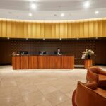 Receptionsskranke i træ på et mindre hotel med siddeområde i baggrunden