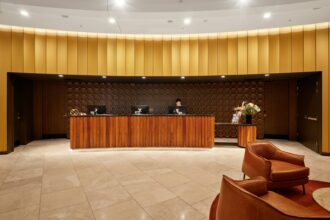 Receptionsskranke i træ på et mindre hotel med siddeområde i baggrunden