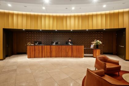 Receptionsskranke i træ på et mindre hotel med siddeområde i baggrunden