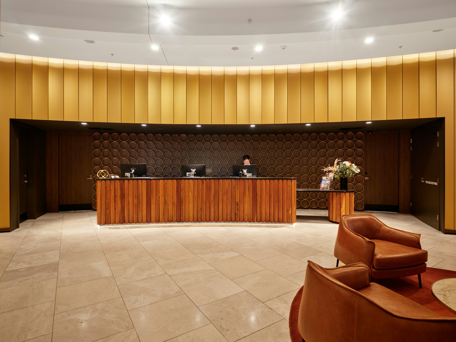 Receptionsskranke i træ på et mindre hotel med siddeområde i baggrunden