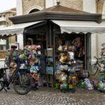 Lille kiosk med aviser og varer i vinduet og en cykel parkeret udenfor på fortovet